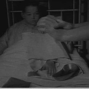 Nurse tending a boy patient's arm, Children's Hospital