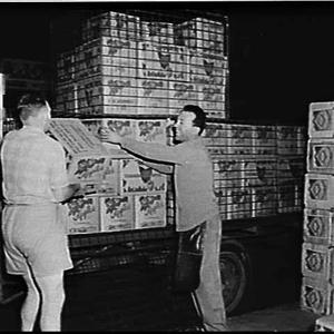 Unloading crates of Tasmanian apples from a truck at Sy...