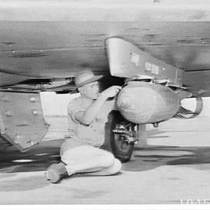 Fitting a bomb to a Canberra bomber, Operation High Soc...